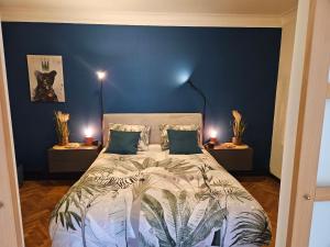 布永Au Pied Du Château的一间卧室配有一张带蓝色墙壁的大床