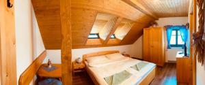 赫林斯科Chalupy Betlém Hlinsko的木天花板的客房内的一张床位