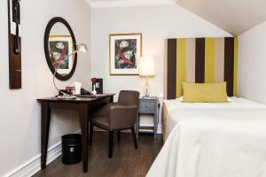 马尔默瑞典精英酒店的一间卧室配有书桌、一张床和镜子