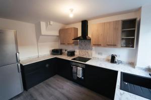 米德尔斯伯勒Middlesbrough contractors digs的厨房配有木制橱柜和冰箱。