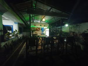莫阿尔博阿Jah’s Anemone Dive Guesthouse的黑暗的房间,晚上配有桌子和椅子
