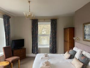 巴克斯顿威斯敏斯特酒店 的一间卧室设有一张床、一台电视和一个窗口。
