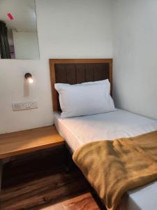 孟买Galaxy Cabin Stay And Dormitory的一间小卧室,配有一张床和镜子