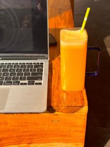 瑞诗凯诗Sailani Lostels的手提电脑旁一杯橙汁