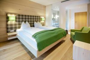 圣吉尔根Hotel Gasthof zur Post的一间卧室配有一张大床和一张绿色椅子