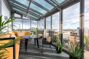 柏林The Tale Luxury Suites的阳台配有桌椅和窗户。