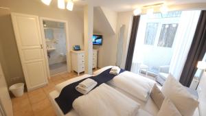 博尔滕哈根Hotel Garni Auszeit的一间带白色床的卧室和一间浴室