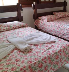 普拉亚多Condomínio Solar dos Peixes的两张睡床彼此相邻,位于一个房间里