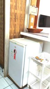 普拉亚多Condomínio Solar dos Peixes的台旁的白色小冰箱