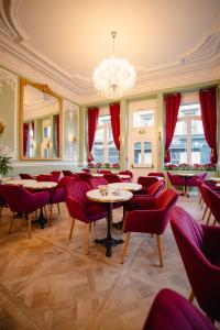 莫尔莱Grand Hôtel de l'Europe的一间带桌椅和吊灯的餐厅