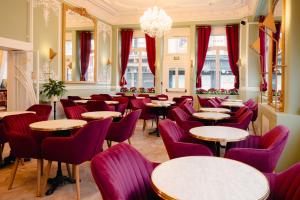 莫尔莱Grand Hôtel de l'Europe的餐厅设有紫色椅子、桌子和窗户