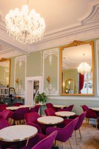 莫尔莱Grand Hôtel de l'Europe的餐厅设有紫色椅子、桌子和镜子