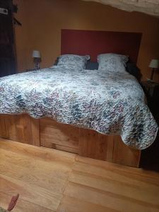 赛尼翁Entre Terre et Ciel.的一间卧室配有一张带花卉棉被的床