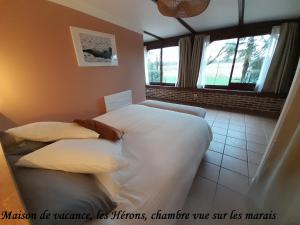 吕村Domaine de l'Ermitage的一间卧室设有两张床和窗户。