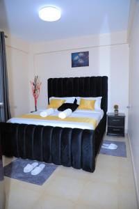 KisiiApartment in kisii Milimani的一张大床,在房间里设有黑色床头板