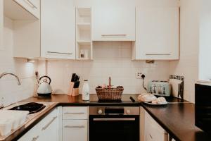 StithiansHigher Trewithen的厨房配有白色橱柜和黑色洗碗机