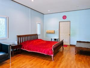 甲米镇Baan Panmala Guesthouse - Ao Luek的卧室配有红色的床和墙上的时钟