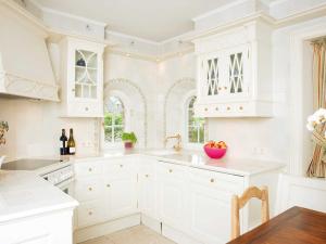 坎彭Hummelhüs von Appartements & Mehr的白色的厨房配有白色的橱柜和桌子