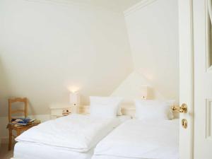 坎彭Hummelhüs von Appartements & Mehr的白色的床、白色床单和枕头