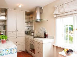 坎彭Inselhaus von Appartements & Mehr的厨房配有白色橱柜、水槽和窗户。