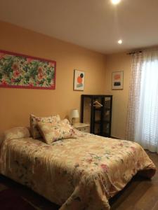 因凡特斯新镇Las Violetas的卧室配有一张床,墙上挂有绘画作品