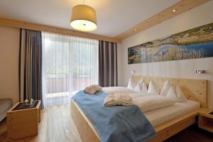 德弗雷根谷地圣雅各布坦德勒酒店的一间卧室设有一张大床和大窗户