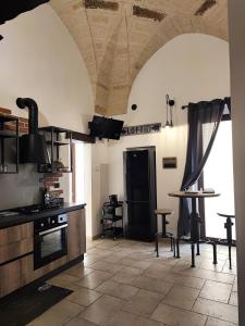 布林迪西Loft Porta Sud的一个带炉灶和桌子的大厨房