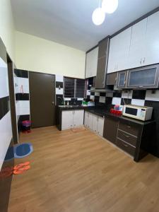 丹那拉打Frosty Hills Homestay的厨房配有黑白橱柜和木地板