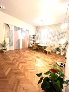 布加勒斯特City Center Unirii Square Private rooms with City View - Shared Amenities的客厅铺有木地板,配有桌子。