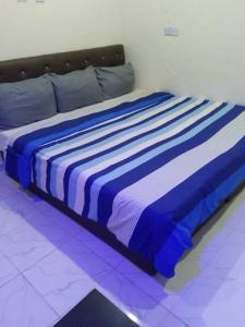 拉各斯JEFFOSA Hotel & Suites的客房内的一张蓝色和白色的床