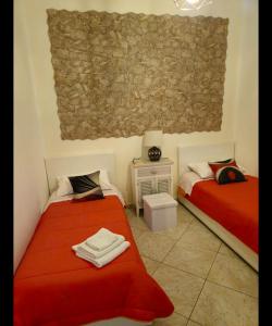 锡拉库扎Residenza Giuseppina的红色床单的客房内的两张床