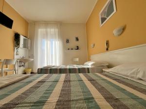 切萨诺博斯科内Hotel Parini的酒店客房设有两张床和窗户。
