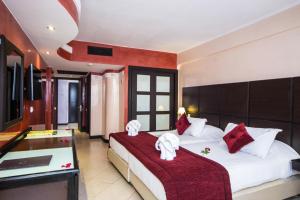 阿加迪尔阿内兹大厦酒店 的一间卧室配有两张带红白色枕头的床