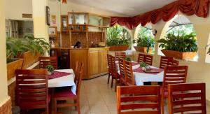 恩德培Sunset Hotel Entebbe的一间带桌椅的餐厅和一间厨房
