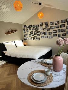 海滨诺德韦克Huisje bij Zee (gratis parkeren)的一间卧室配有床和一张带盘子和鲜花的桌子