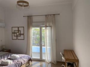 雅典Azure House的一间卧室设有一张床和一个滑动玻璃门