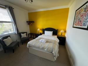 查尔德Watermead House的一间卧室设有一张床和黄色的墙壁