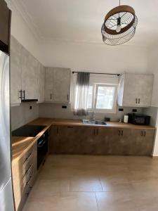 雅典Azure House的厨房配有木制橱柜、水槽和吊灯。