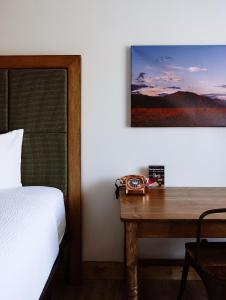 陶斯Taos Valley Lodge的一间卧室配有一张床和一张木桌