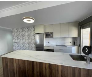 阿桂拉斯Clauadris Home ideal para familias的一间厨房,里面配有一个白色的大台面