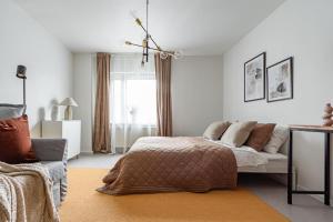 斯德哥尔摩Modern Charm Stylish Studio in Sodermalm的一间卧室配有一张床、一张沙发和一个窗口