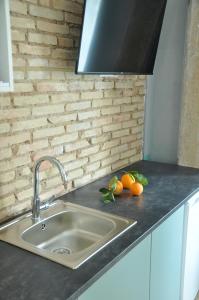 瓦伦西亚La Casa Verde - Ruzafa的厨房柜台配有水槽和一些橙子