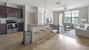 奥兰多Landing Modern Apartment with Amazing Amenities (ID9660X22)的厨房以及带柜台和凳子的客厅。