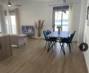 阿桂拉斯Clauadris Home ideal para familias的一间带桌子和蓝色椅子的用餐室