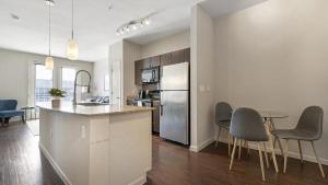 奥斯汀Landing Modern Apartment with Amazing Amenities (ID4179X58)的厨房配有冰箱和桌椅