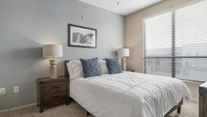 奥斯汀Landing Modern Apartment with Amazing Amenities (ID4179X58)的一间卧室配有一张带两盏灯的床和一扇窗户。