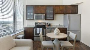 奥马哈Landing Modern Apartment with Amazing Amenities (ID1178X938)的带桌椅的厨房以及带不锈钢用具的厨房。