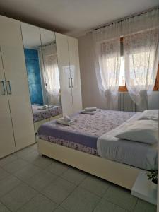 圣皮耶罗阿谢韦CASA SOSSI的一间卧室配有一张床和一面大镜子