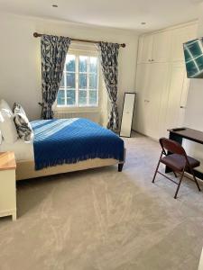 BuckinghamshireDenham Mount的一间卧室配有一张床、一张书桌和一个窗户。