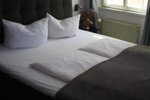 瓦尔多夫艾布帕林泽瓦尔多夫餐厅酒店的一张带白色床单和枕头的床